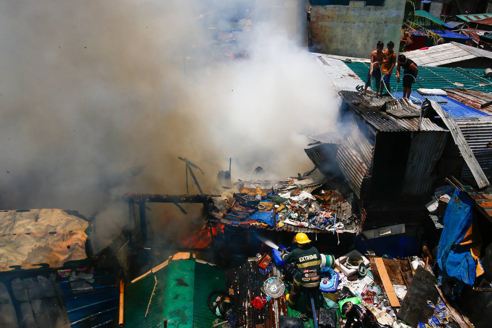 Firefighters and residents work together to control a raging third-alarm fire at the Baseco Compound in Port Area, Manila, on 30 May 2026. The incident comes just a week after a separate blaze gutted a nearby coastal community across the Pasig River.