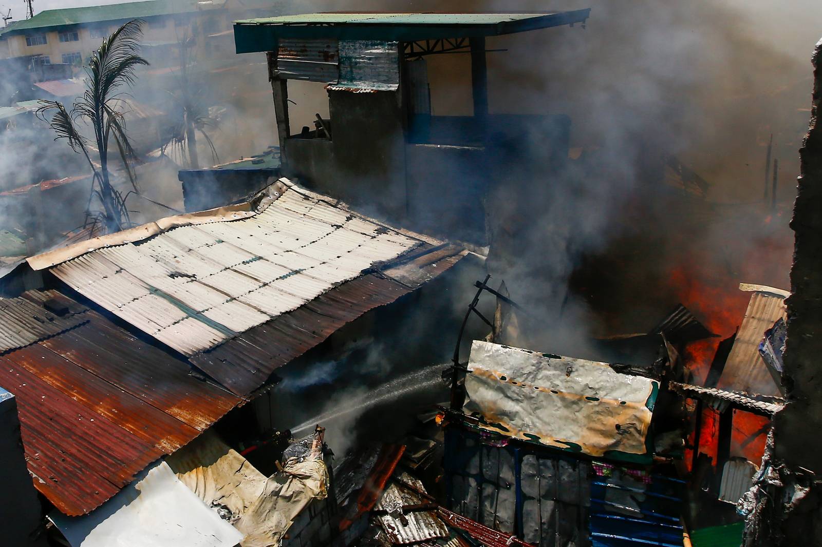 Firefighters and residents work together to control a raging third-alarm fire at the Baseco Compound in Port Area, Manila, on 30 May 2026. The incident comes just a week after a separate blaze gutted a nearby coastal community across the Pasig River.