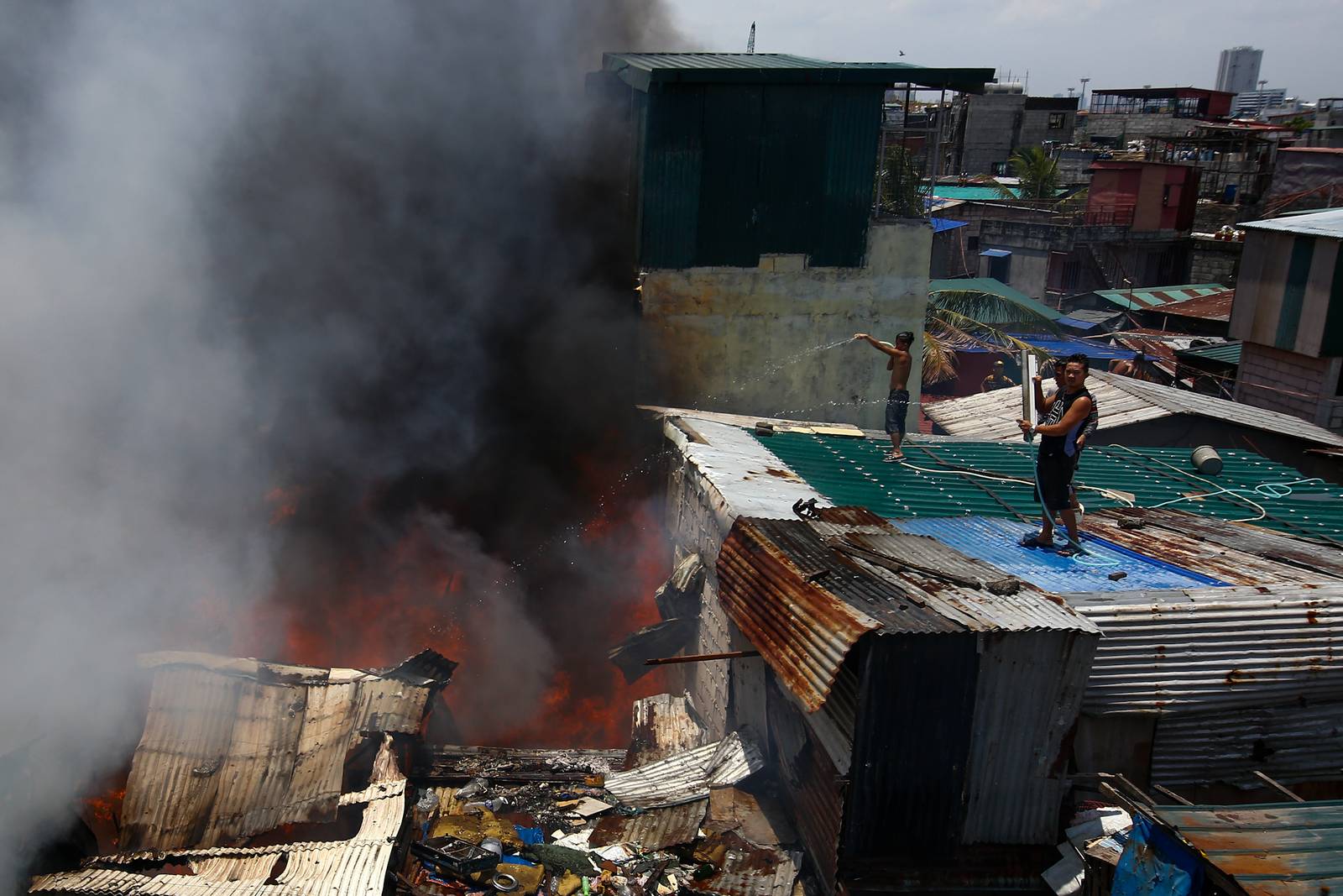 Firefighters and residents work together to control a raging third-alarm fire at the Baseco Compound in Port Area, Manila, on 30 May 2026. The incident comes just a week after a separate blaze gutted a nearby coastal community across the Pasig River.