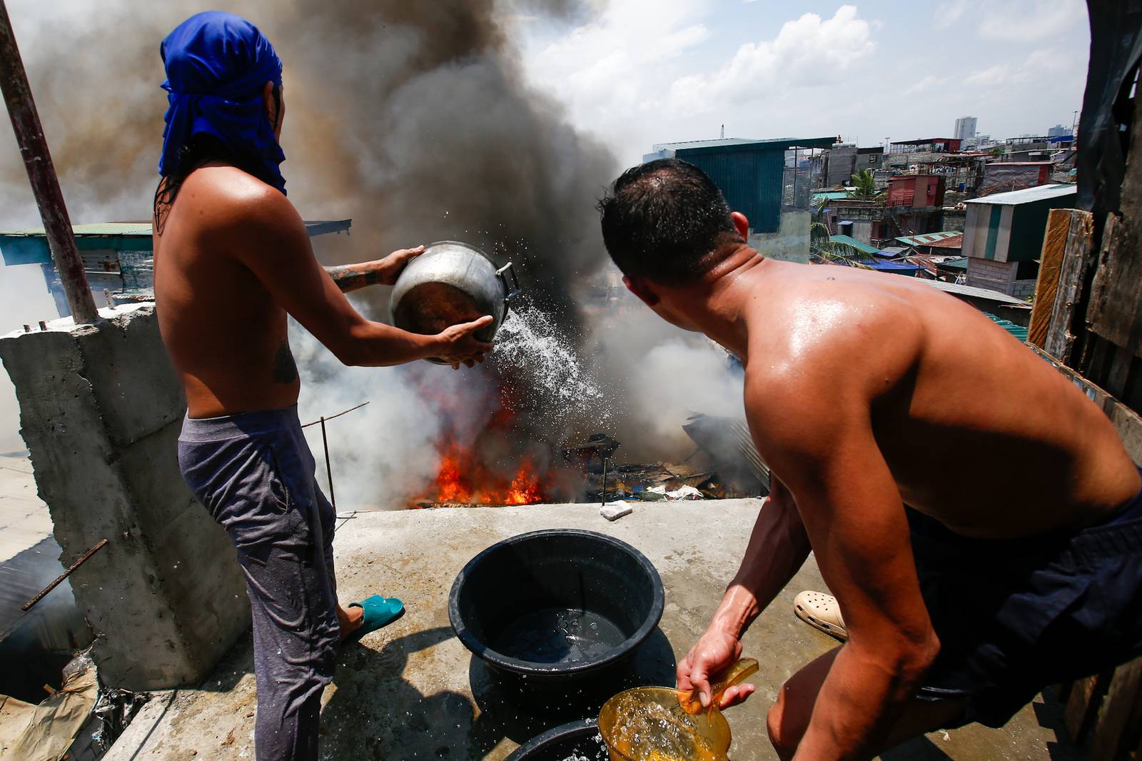 Firefighters and residents work together to control a raging third-alarm fire at the Baseco Compound in Port Area, Manila, on 30 May 2026. The incident comes just a week after a separate blaze gutted a nearby coastal community across the Pasig River.