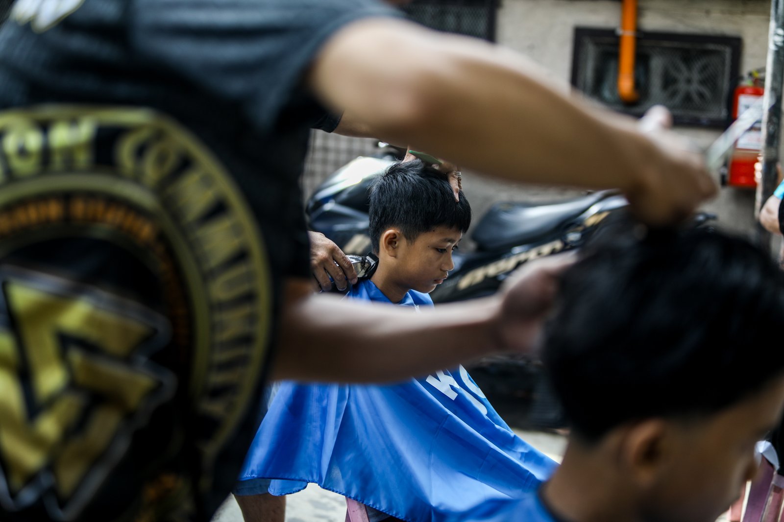 Members of the Triskelion Grand Fraternity jumpstarted a back-to-school free haircut outreach program at Kamias Extension, Quezon City on Sunday, 31 May, 2026. Thirty community students for the upcoming school year have been provided with haircuts along the community covered court.| Aram Lascano