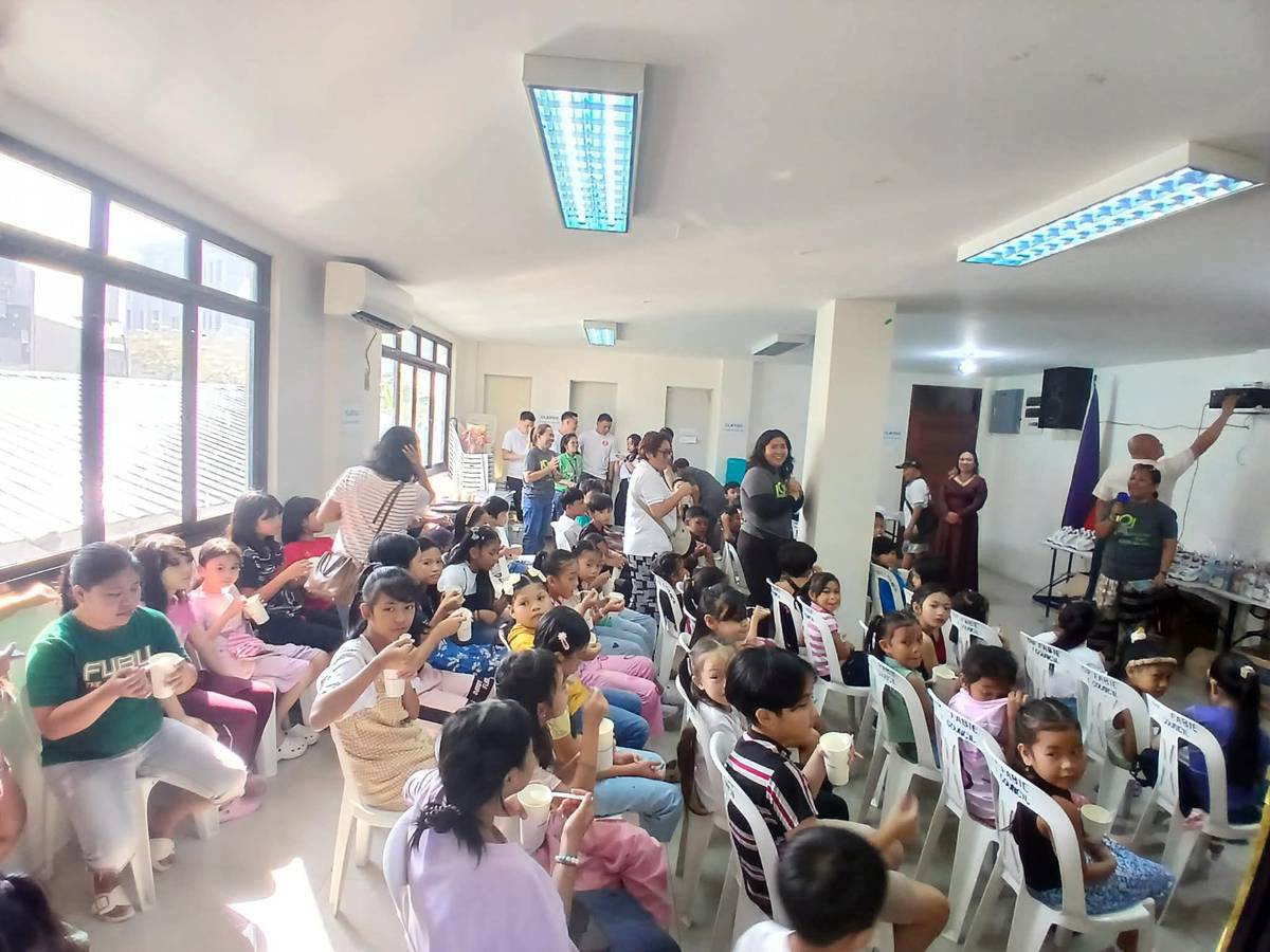 GRADE-SCHOOLERS from Barangay San Agustin enjoy meals from Solaire Cares and LOLA Foundation.