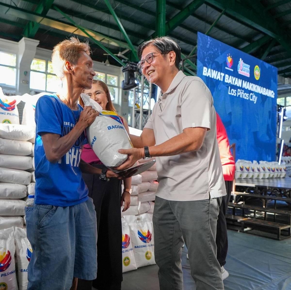 PRESIDENT Ferdinand Marcos Jr. hands a 10-kilo rice pack to a Las Pinas City resident.