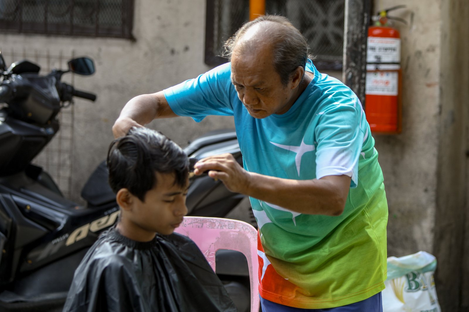 Members of the Triskelion Grand Fraternity jumpstarted a back-to-school free haircut outreach program at Kamias Extension, Quezon City on Sunday, 31 May, 2026. Thirty community students for the upcoming school year have been provided with haircuts along the community covered court.| Aram Lascano