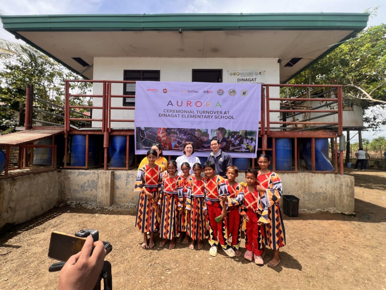 BRIDGING last-mile school Aboitiz Foundation Inc. president Ana Margarita ‘Ginggay’ Hontiveros-Malvar (center, white shirt) leads the turnover of solar power, connectivity and blended learning support at Dinagat Elementary School, Bunawan, Agusan del Sur. With her are other major partners of the project and school pupils.