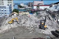 Systematic clearing and retrieval operations continue at the collapse site in Angeles City, with heavy machinery carefully removing debris to support ongoing search efforts.