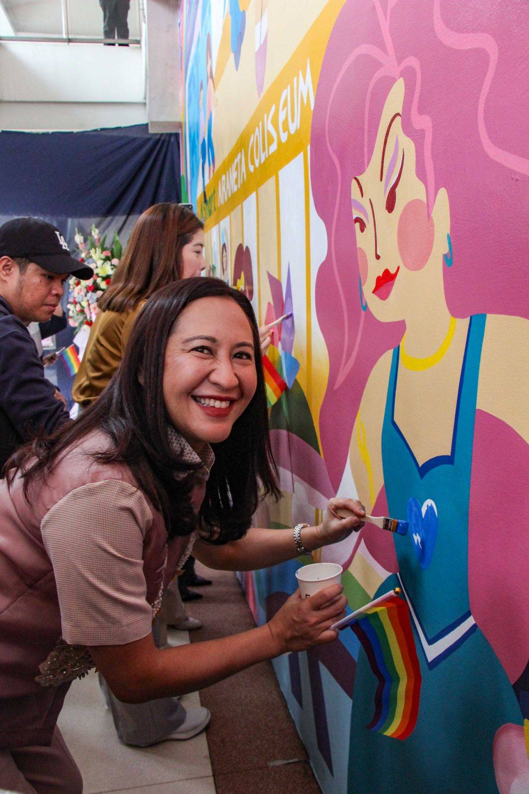 QUEZON City Mayor Joy G. Belmonte adding finishing touches to the mural.