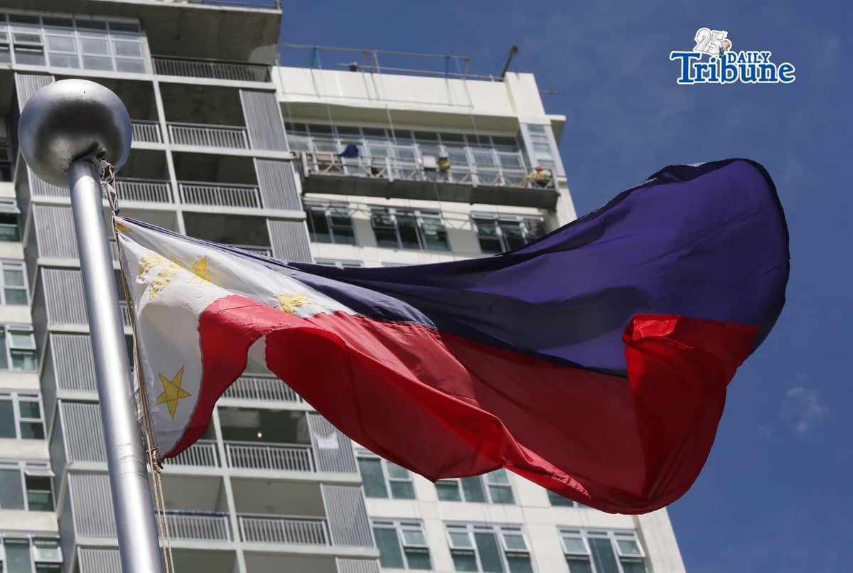 (June 11 2026) Philippine Flag waving, while the construction workers busy working at the top of the ongoing construction building in Quezon City, ahead of the observance of the Philippine Independence Day. Photo/Analy Labor