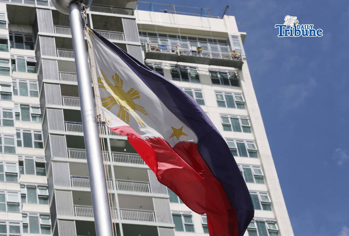 (June 11 2026) Philippine Flag waving, while the construction workers busy working at the top of the ongoing construction building in Quezon City, ahead of the observance of the Philippine Independence Day. Photo/Analy Labor