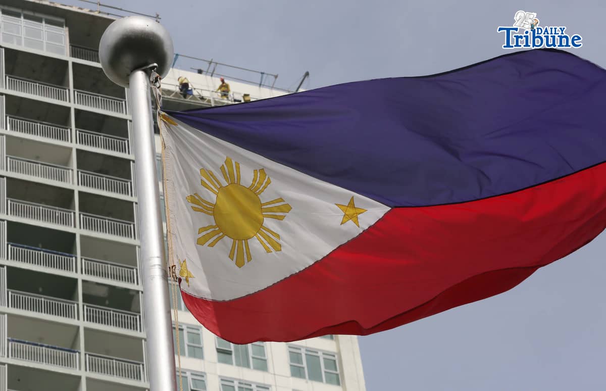 (June 11 2026) Philippine Flag waving, while the construction workers busy working at the top of the ongoing construction building in Quezon City, ahead of the observance of the Philippine Independence Day. Photo/Analy Labor
