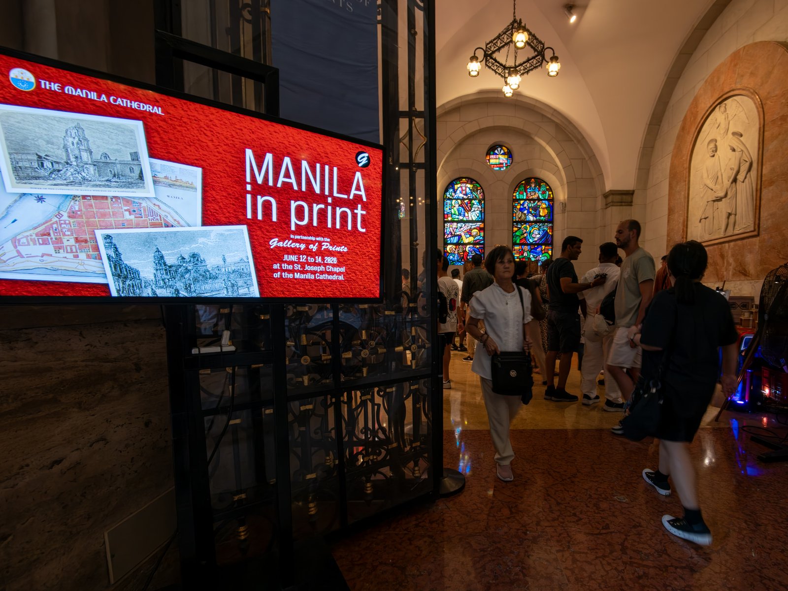 Visitors immerse themselves in history at the Manila in Prints exhibition, held at the Manila Cathedral on 14 June 2026. The display features rare antique prints, historical maps, and archival materials highlighting the rich heritage of the cathedral, the Walled City - Intramuros, and greater Manila.