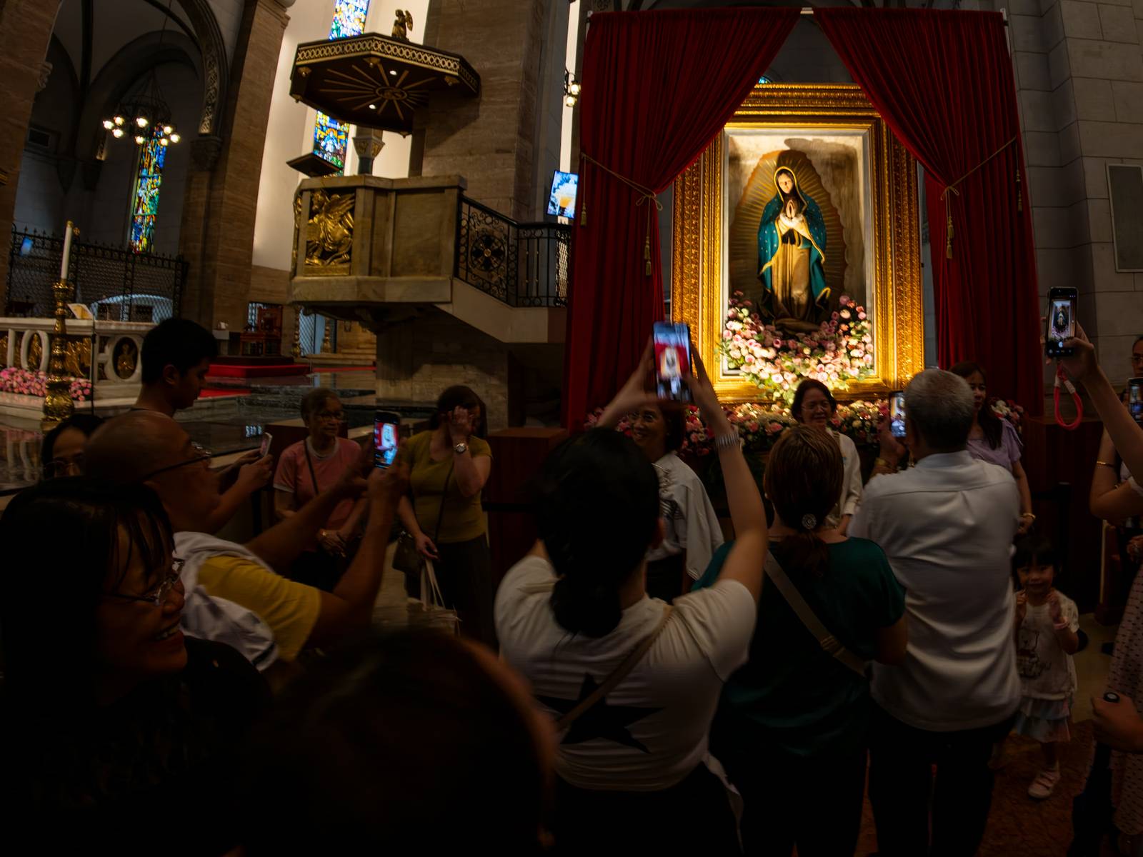 Catholic devotees line up before the images of Our Lady of Guadalupe and St. Juan Diego at the Manila Cathedral in Intramuros, Manila on 14 June 2026. The replica, sent to the Philippines from Mexico, will remain at the cathedral until 18 June before traveling to churches across Luzon, Visayas, and Mindanao until December 2026.