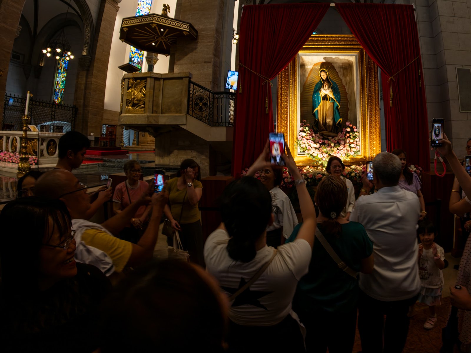 Catholic devotees line up before the images of Our Lady of Guadalupe and St. Juan Diego at the Manila Cathedral in Intramuros, Manila on 14 June 2026. The replica, sent to the Philippines from Mexico, will remain at the cathedral until 18 June before traveling to churches across Luzon, Visayas, and Mindanao until December 2026.