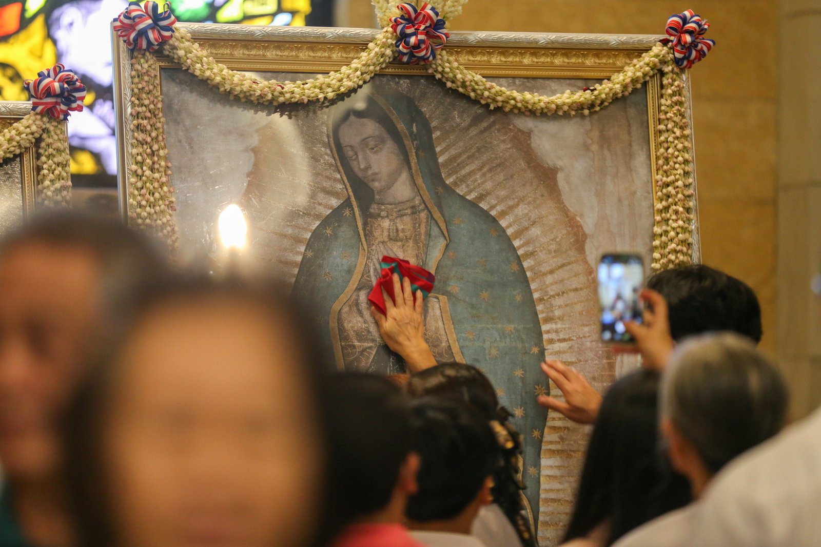 Catholic devotees line up before the images of Our Lady of Guadalupe and St. Juan Diego at the Manila Cathedral in Intramuros, Manila on 14 June 2026. The replica, sent to the Philippines from Mexico, will remain at the cathedral until 18 June before traveling to churches across Luzon, Visayas, and Mindanao until December 2026.