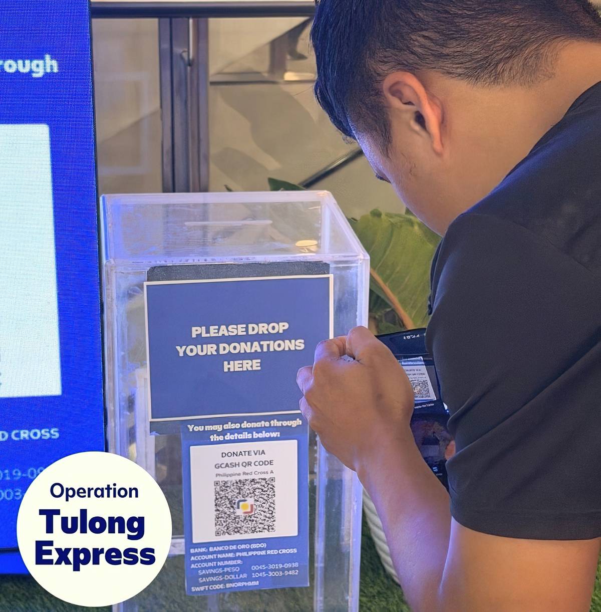 A donor uses his mobile phone to provide assistance through an Operation Tulong Express counter. SM malls served as support centers for the massive relief effort for the Mindanao earthquake victims.