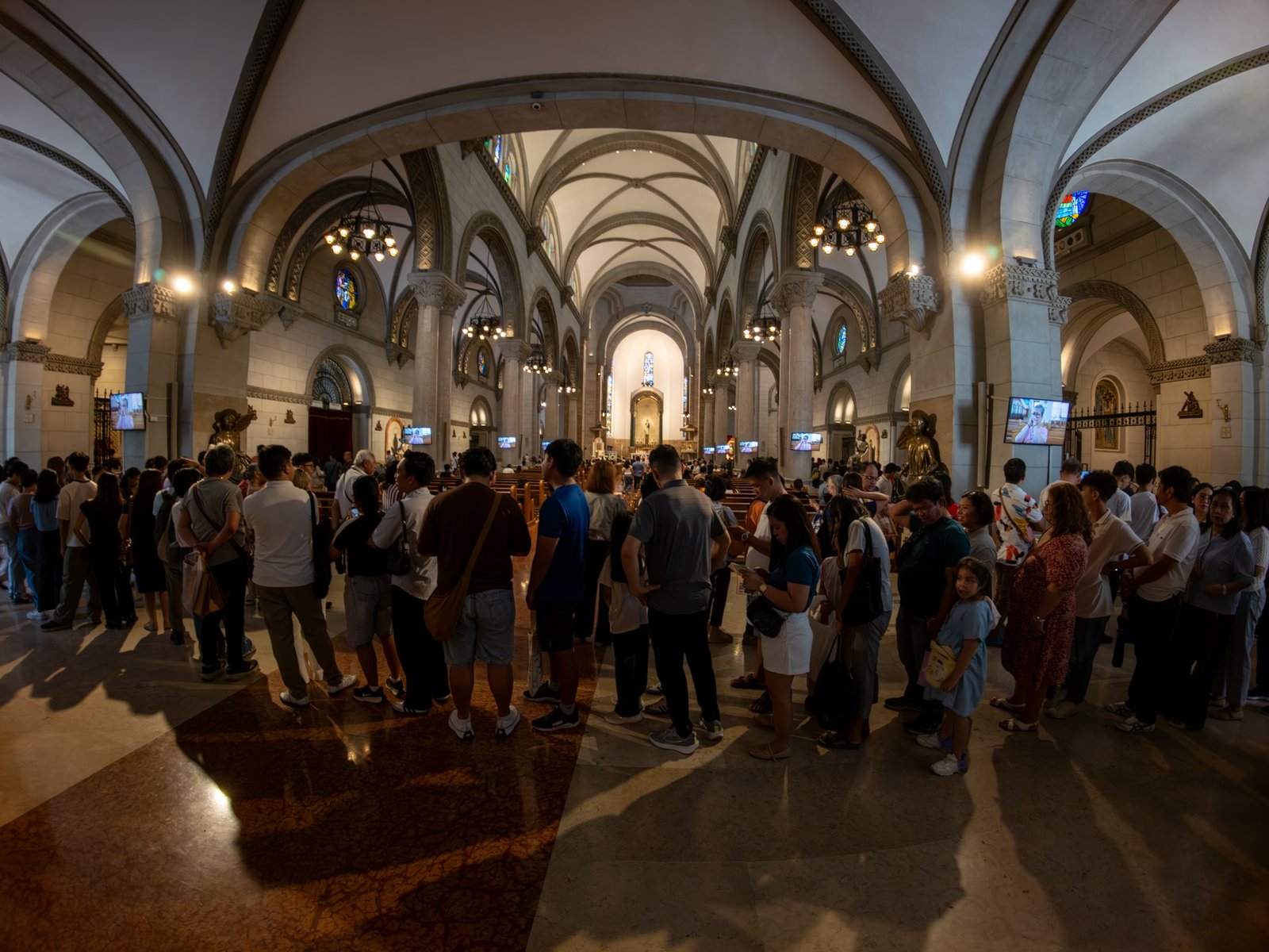 Catholic devotees line up before the images of Our Lady of Guadalupe and St. Juan Diego at the Manila Cathedral in Intramuros, Manila on 14 June 2026. The replica, sent to the Philippines from Mexico, will remain at the cathedral until 18 June before traveling to churches across Luzon, Visayas, and Mindanao until December 2026.