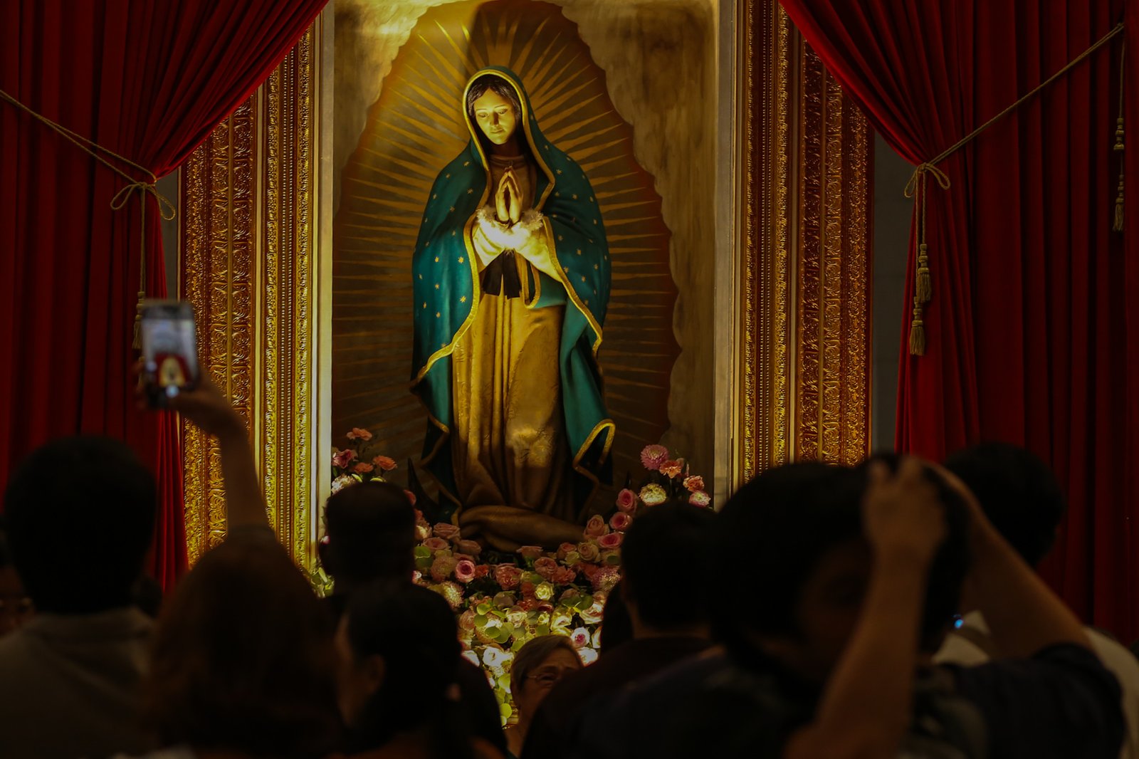 Catholic devotees line up before the images of Our Lady of Guadalupe and St. Juan Diego at the Manila Cathedral in Intramuros, Manila on 14 June 2026. The replica, sent to the Philippines from Mexico, will remain at the cathedral until 18 June before traveling to churches across Luzon, Visayas, and Mindanao until December 2026.