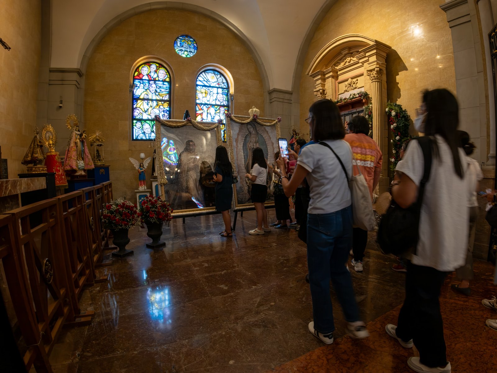 Catholic devotees line up before the images of Our Lady of Guadalupe and St. Juan Diego at the Manila Cathedral in Intramuros, Manila on 14 June 2026. The replica, sent to the Philippines from Mexico, will remain at the cathedral until 18 June before traveling to churches across Luzon, Visayas, and Mindanao until December 2026.