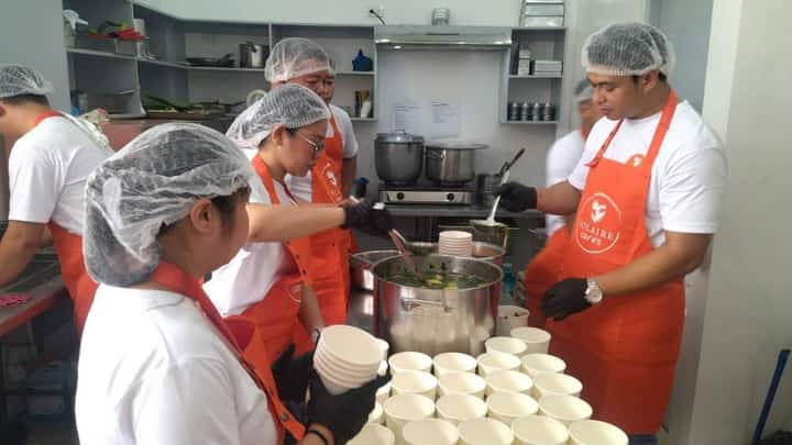 VOLUNTEERS from Solaire Cares prepare hot meals for children of Barangay San Dionisio, Paranaque City.