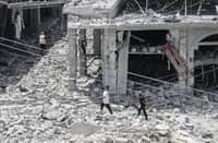 PEOPLE make their way through the heavily damaged historic market of Nabatieh as residents displaced by fighting return to southern Lebanon.