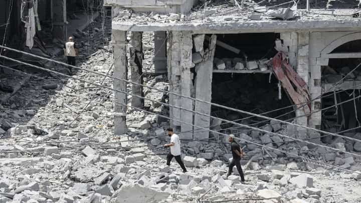 PEOPLE make their way through the heavily damaged historic market of Nabatieh as residents displaced by fighting return to southern Lebanon.
