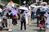 SOUTH Korean protesters hold umbrellas and wave national flags outside the SK Olympic Handball Gymnasium, which served as a vote-counting center, in Seoul on 17 June 2026, amid ongoing protests demanding a rerun of the 3 June local elections due to ballot paper shortages.