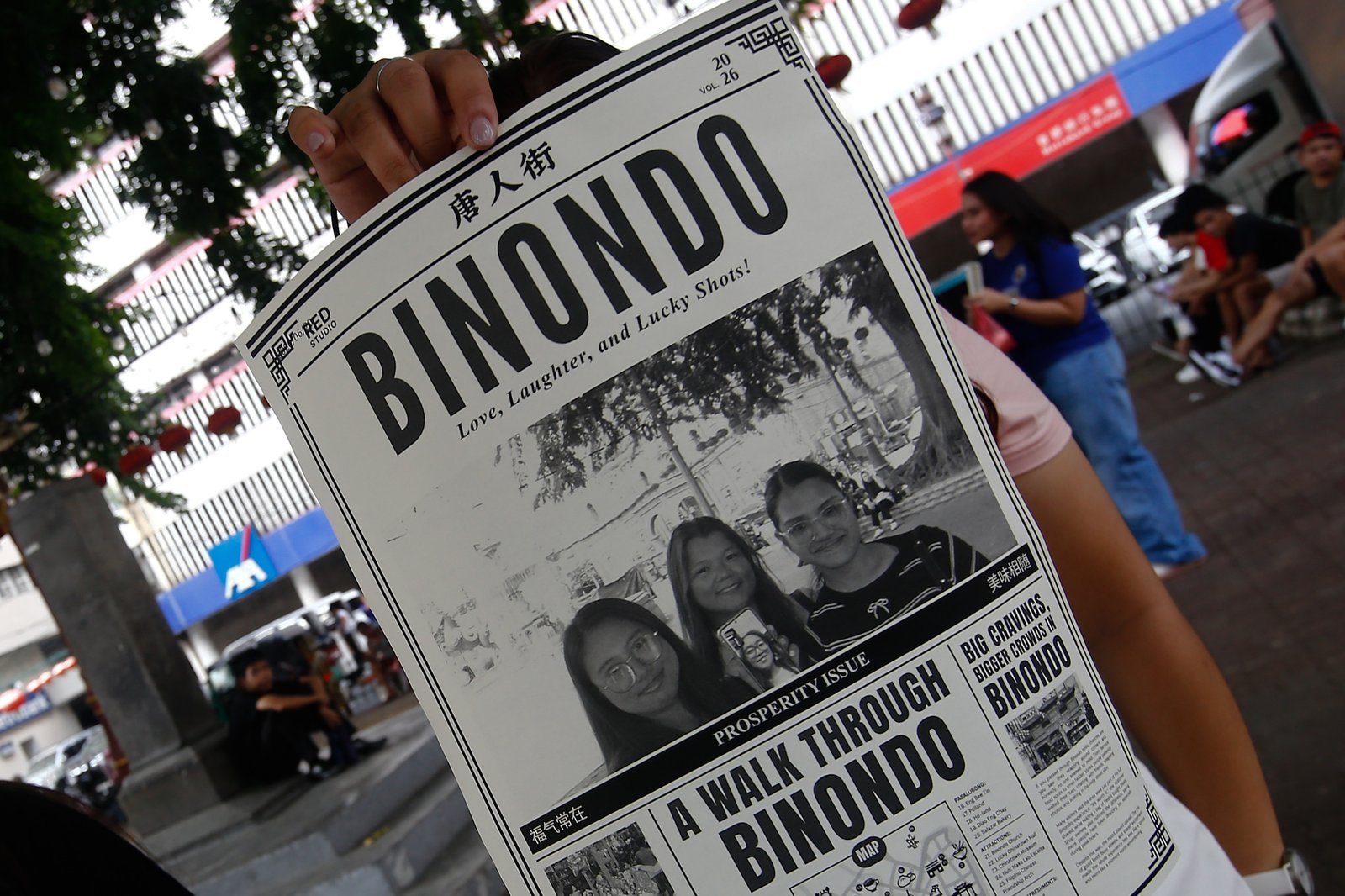 Tourists line up for a photo session at a booth in Plaza San Lorenzo Ruiz in Binondo, Manila on Saturday, 20 June 2026. The photo booth, which prints a vintage-style newspaper alongside a downloadable digital copy, is becoming a popular destination for Binondo-goers.