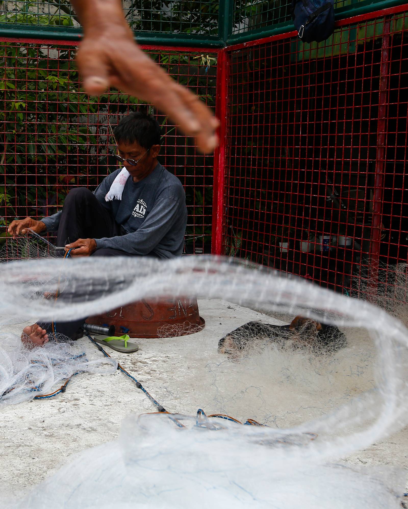 Fishermen repair and assemble nets at a neighborhood basketball court in Navotas City on Saturday, 20 June 2026, as they prepare for their next fishing trip in municipal waters.