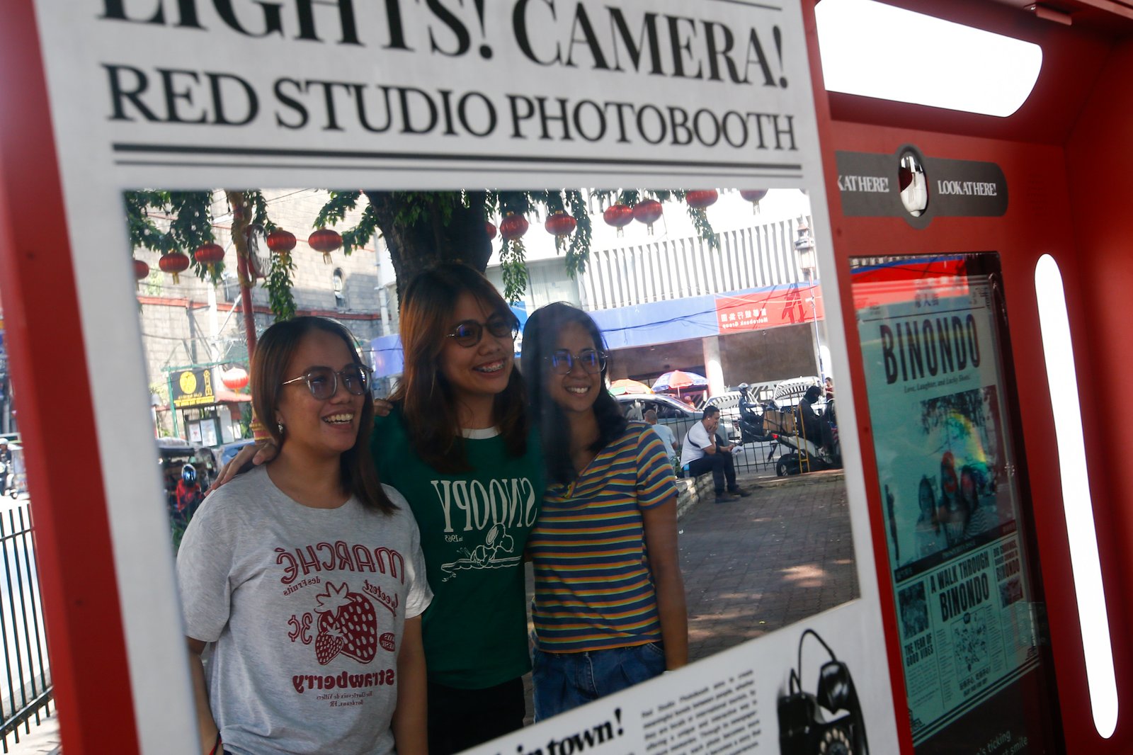 Tourists line up for a photo session at a booth in Plaza San Lorenzo Ruiz in Binondo, Manila on Saturday, 20 June 2026. The photo booth, which prints a vintage-style newspaper alongside a downloadable digital copy, is becoming a popular destination for Binondo-goers.