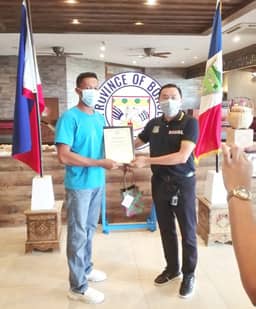 SILENT hero in Bohol. Bohol Provincial Governor Arthur C. Yap (right) awarding Meralco lineman Bryan Urriza (left) a certificate of appreciation for helping BOHECO Il to restore the electricity service in the area after the onslaught of typhoon Odette in 2021.