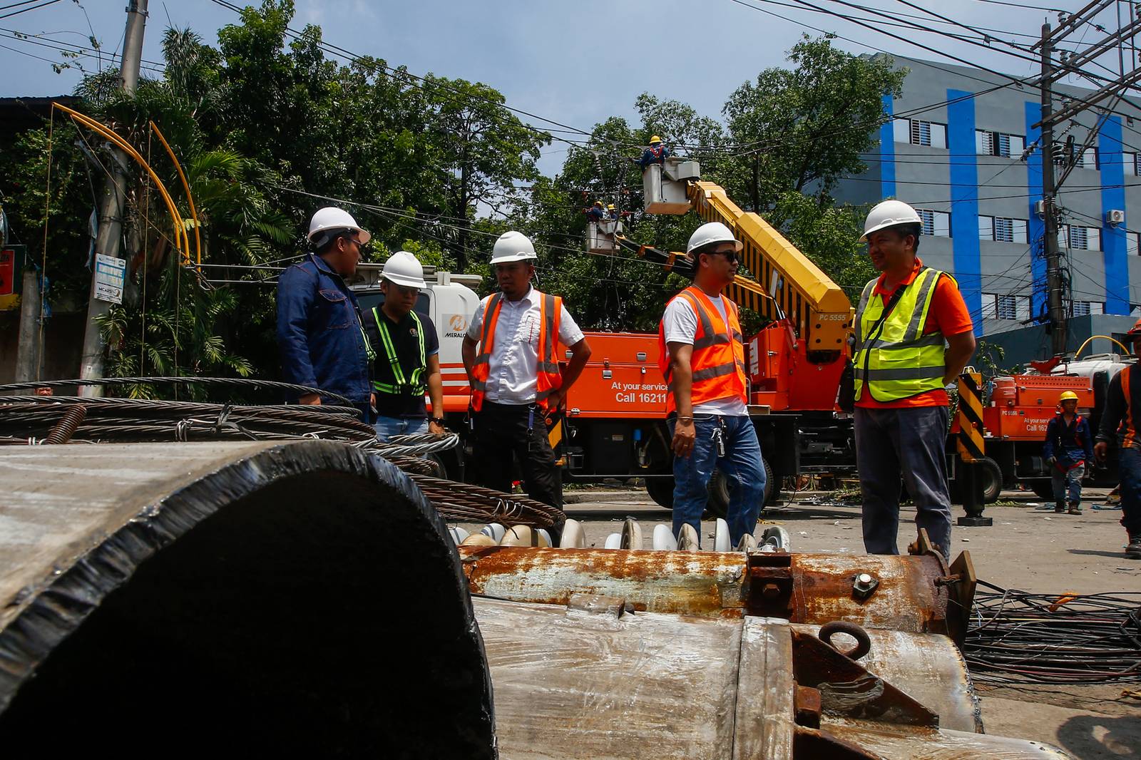 Workers from Meralco repair downed power lines in Malabon City on 22 June 2026, following a severe downpour the previous evening. Sudden strong winds and heavy rains caused three electrical posts to topple, cutting off electricity, phone lines, and internet services for local residents.
