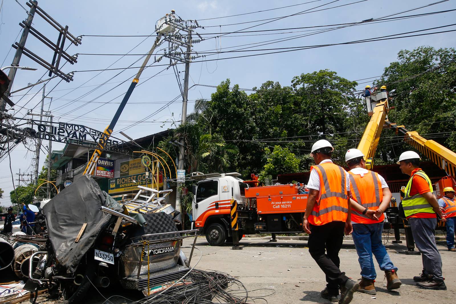 Workers from Meralco repair downed power lines in Malabon City on 22 June 2026, following a severe downpour the previous evening. Sudden strong winds and heavy rains caused three electrical posts to topple, cutting off electricity, phone lines, and internet services for local residents.