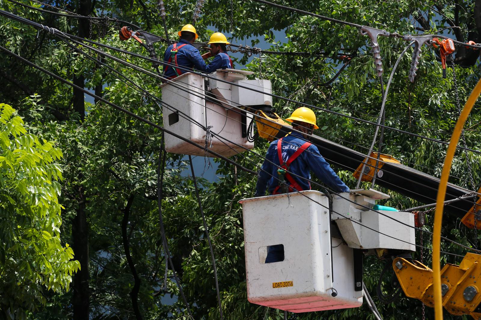 Workers from Meralco repair downed power lines in Malabon City on 22 June 2026, following a severe downpour the previous evening. Sudden strong winds and heavy rains caused three electrical posts to topple, cutting off electricity, phone lines, and internet services for local residents.