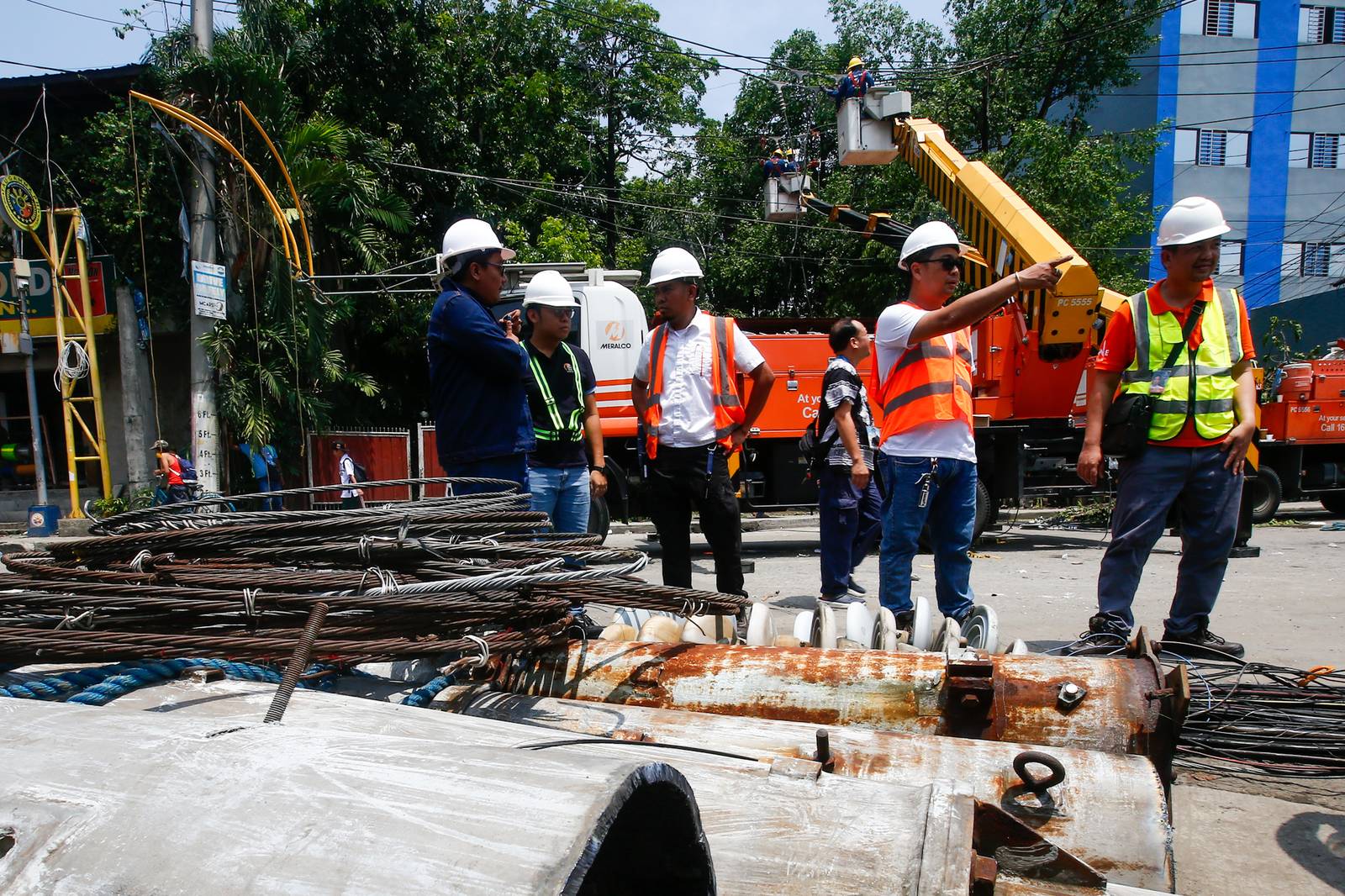 Workers from Meralco repair downed power lines in Malabon City on 22 June 2026, following a severe downpour the previous evening. Sudden strong winds and heavy rains caused three electrical posts to topple, cutting off electricity, phone lines, and internet services for local residents.