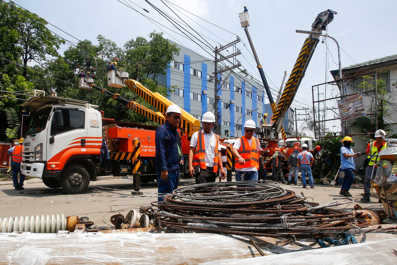 Workers from Meralco repair downed power lines in Malabon City on 22 June 2026, following a severe downpour the previous evening. Sudden strong winds and heavy rains caused three electrical posts to topple, cutting off electricity, phone lines, and internet services for local residents.
