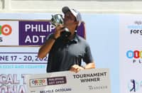 ITALIAN golfer Michele Ortolani kisses the championship trophy while holding the winner’s check after topping the Philippine ADT Open at Luisita Golf and Country Club.