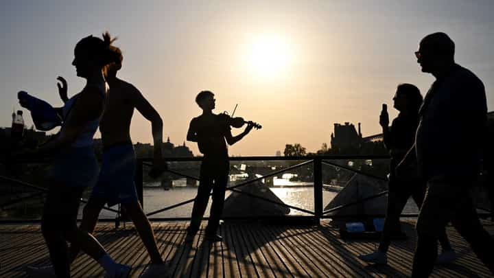 A VIOLINIST plays under the sun on the Pont des Arts footbridge during the annual Fête de la Musique street festival on 21 June 2026, as a severe heatwave grips parts of France, where multiple departments remain under red alert.