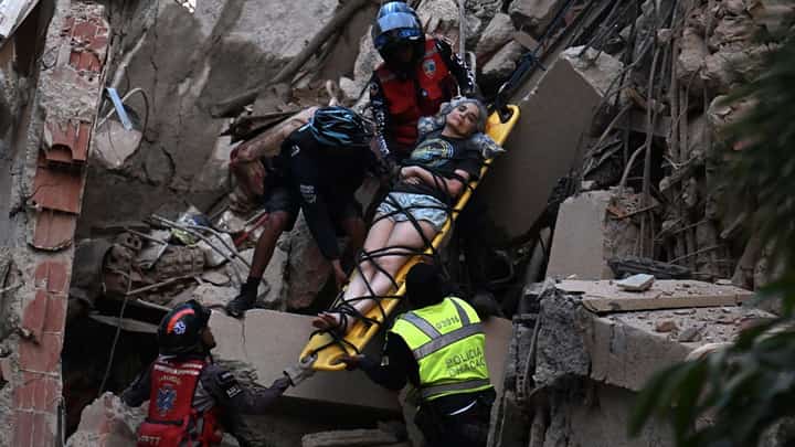 Rescue workers carry a person on a stretcher out of a collapsed building following an earthquake in Caracas on June 24, 2026. Two earthquakes of magnitude 7.2 and 7.5 struck the same area of Venezuela on the evening of June 24, causing buildings to collapse, according to the United States Geological Survey (USGS) and AFP journalists. The quakes drove residents of the capital, Caracas, into the streets.