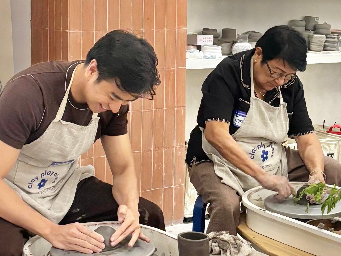 MOTHER and son bonding taking pottery classes.