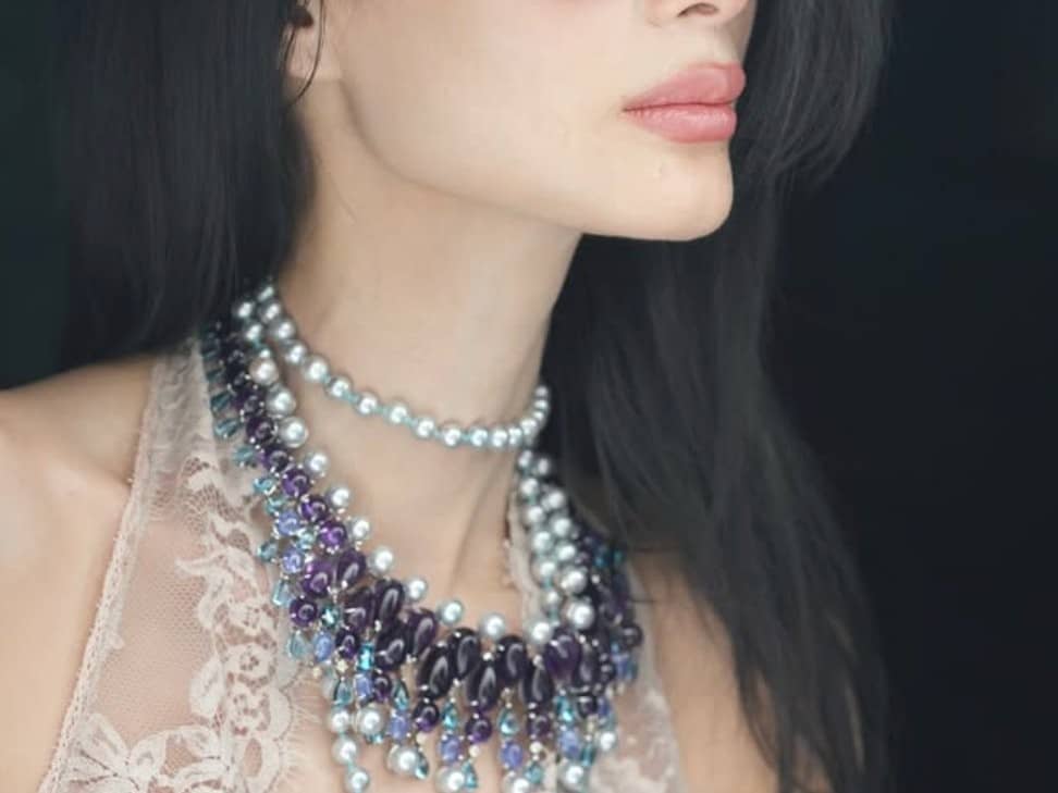 LAYERED necklace with purple and blue teardrop gemstones and pearl accents.