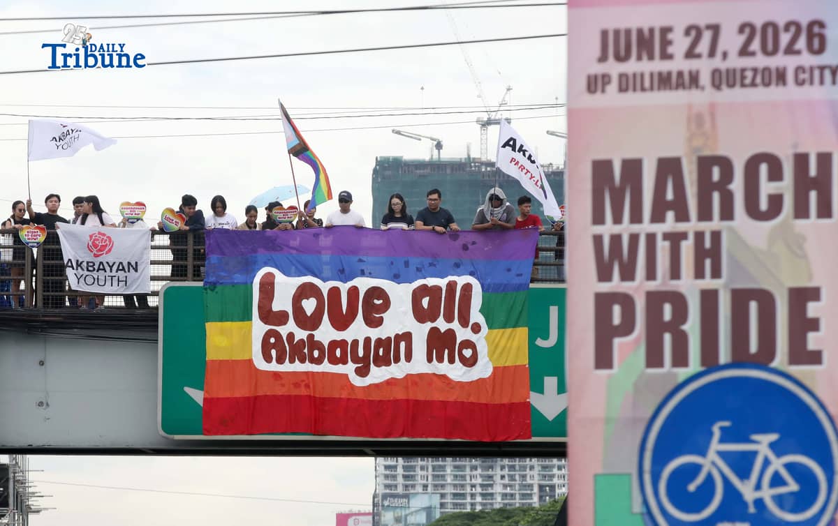 A day before the annual Pride March, volunteers from Akbayan Youth unfurl a rainbow banner reading, “Love All, Akbayan Mo! #PrideEquality,” on the Philcoa footbridge in Quezon City on Friday, calling for equality, dignity and recognition of every person's identity. | Photo by Analy Labor