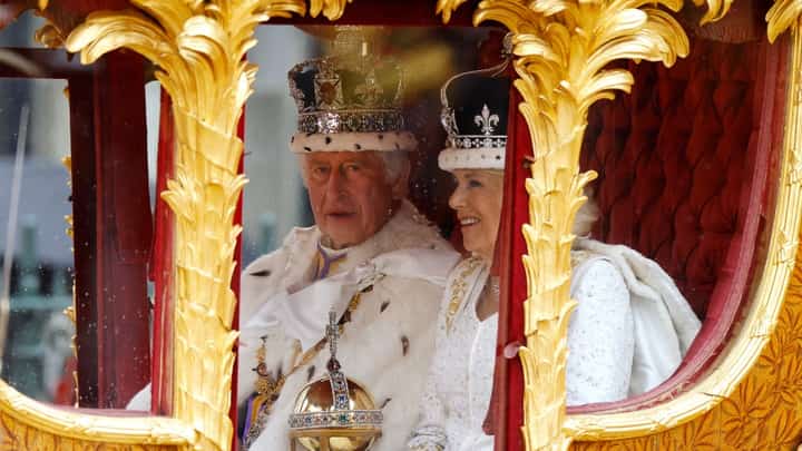 Britain's King Charles III and Britain's Queen Camilla (R) travel in the Gold State Coach back to Buckingham Palace from Westminster Abbey in central London on May 6, 2023, after their coronations. Britain's King Charles III is expected to reveal his personal tax bill in a bid to improve transparency on June 25, 2026, as royal finances come under increasing public scrutiny in Britain.