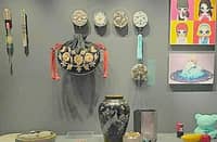 TRADITIONAL Korean artifacts alongside modern pop art, featuring items like a decorative black purse (bokjumeoni) and intricate hair accessories.