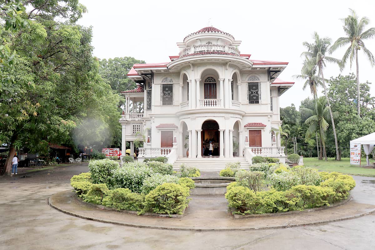 MOLO MANSION, Molo, Iloilo City, Iloilo. Also known as the Lacson-Yusay Mansion, it was built in 1926, combining Neoclassical symmetry with Art Deco elegance. Its design features a semi-circular portico, arcaded veranda, molded stringcourse with scroll-shaped corbels, and a terracotta-tiled, hip-and-valley roof adorned with floral vents and a mirador tower. Located across Molo Plaza and Molo Church, the mansion — now owned by the SM Group — has been restored as a cultural and commercial landmark.