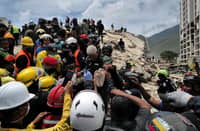 RESCUERS carry a person after being pulled alive from the rubble of a collapsed building in Caraballeda, La Guaira state, Venezuela, on 28 June 2026, following earthquakes.
