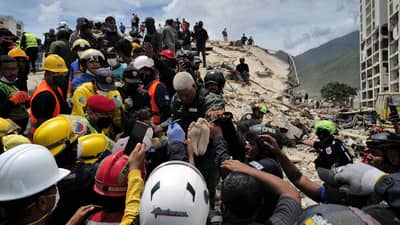 RESCUERS carry a person after being pulled alive from the rubble of a collapsed building in Caraballeda, La Guaira state, Venezuela, on 28 June 2026, following earthquakes.