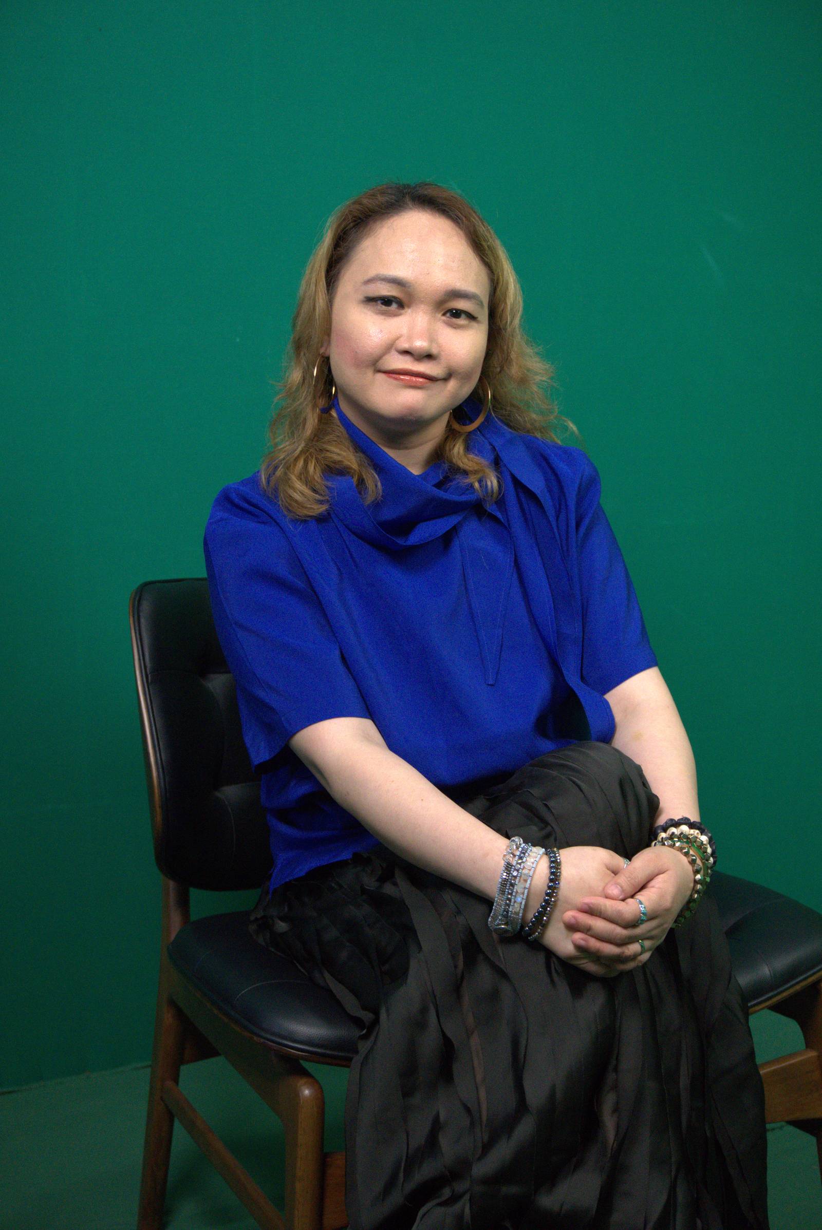 ASSOCIATE Life editor Deni Bernardo wears a navy blue top worn over a crinkled black dress, creating a striking layered ensemble.
