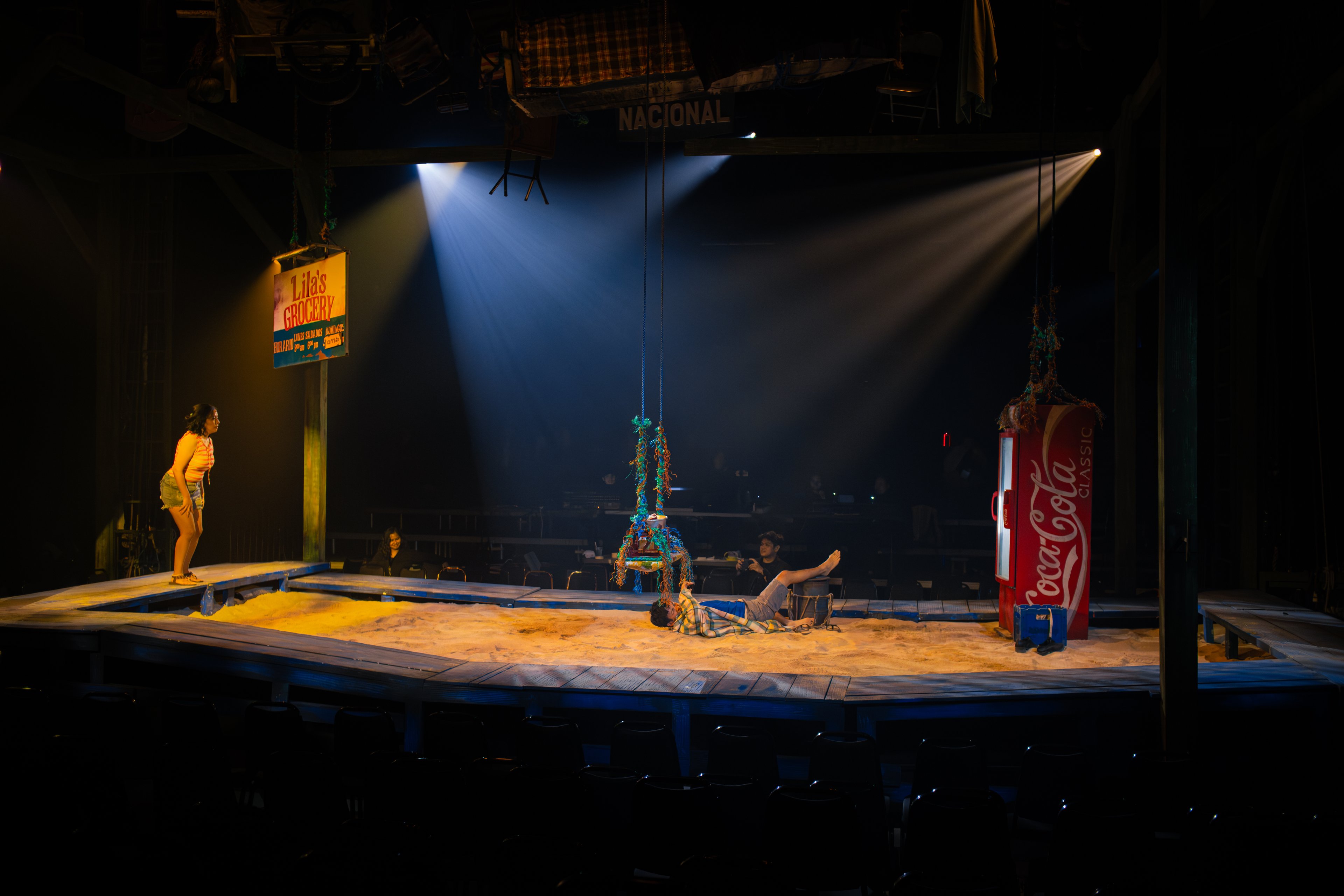 The stage resembles a vast sandbox, a place suspended between memory and myth.