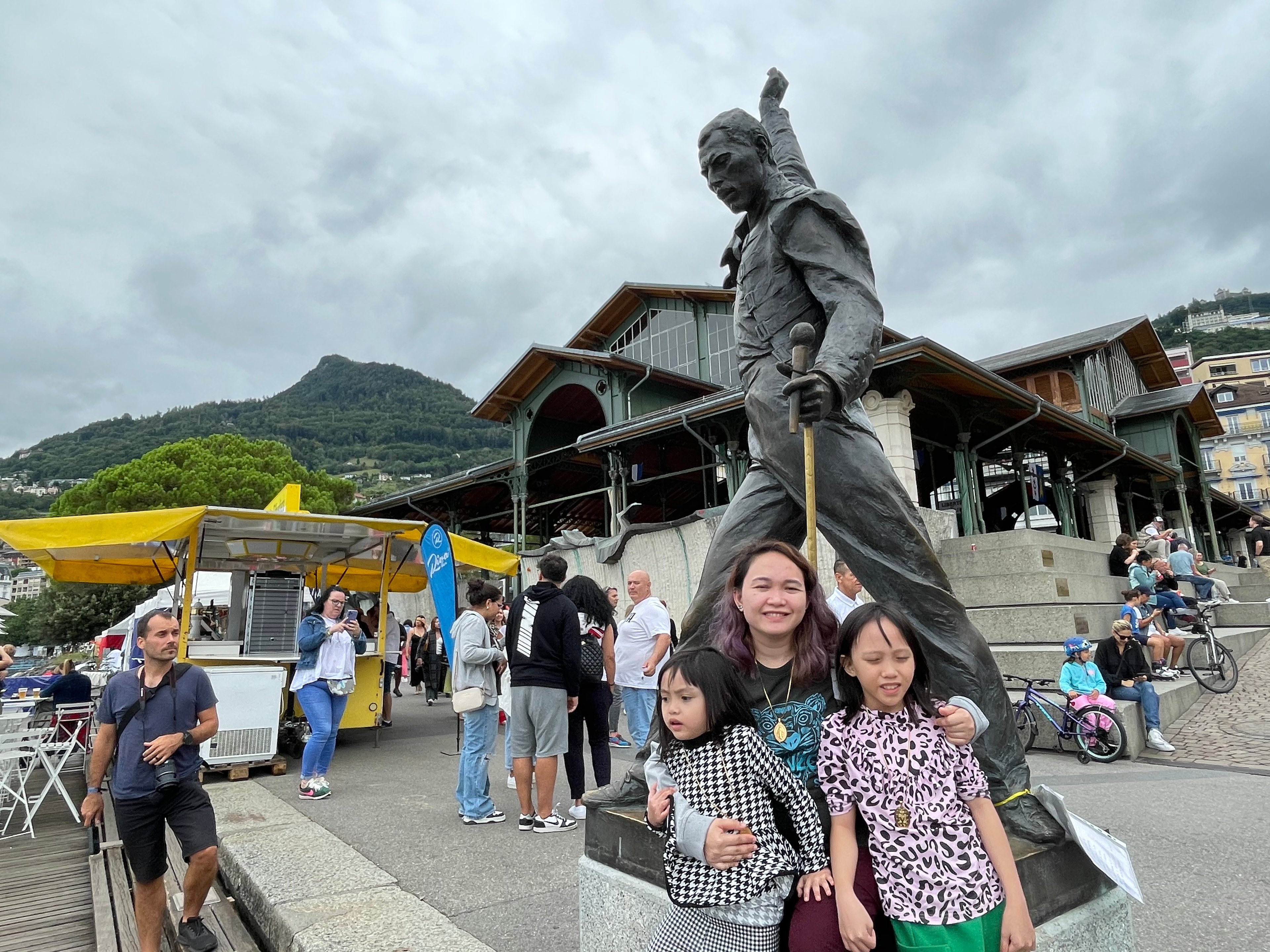 TOURISTS and fans with the bronze statue of Freddie Mercury.