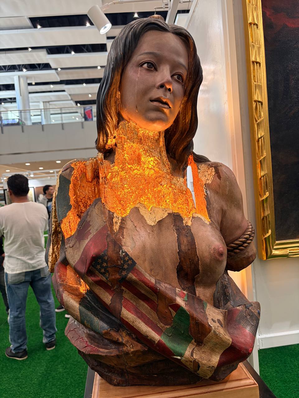 WILLY Layug’s wooden sculpture portrays a grieving woman draped in torn Western flags.